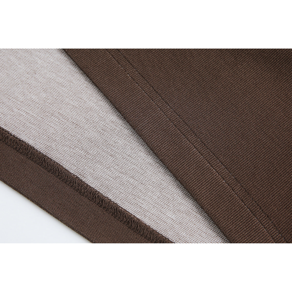 Close-up of brown fabric, a stitched seam, and a light-colored inner layer.