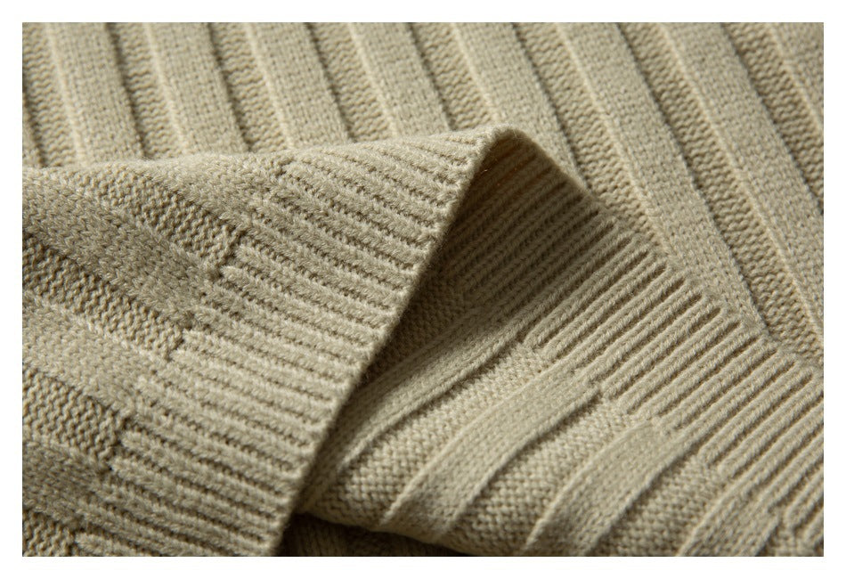 Close-up of a folded ribbed edge on the beige sweater, showing the knit texture.