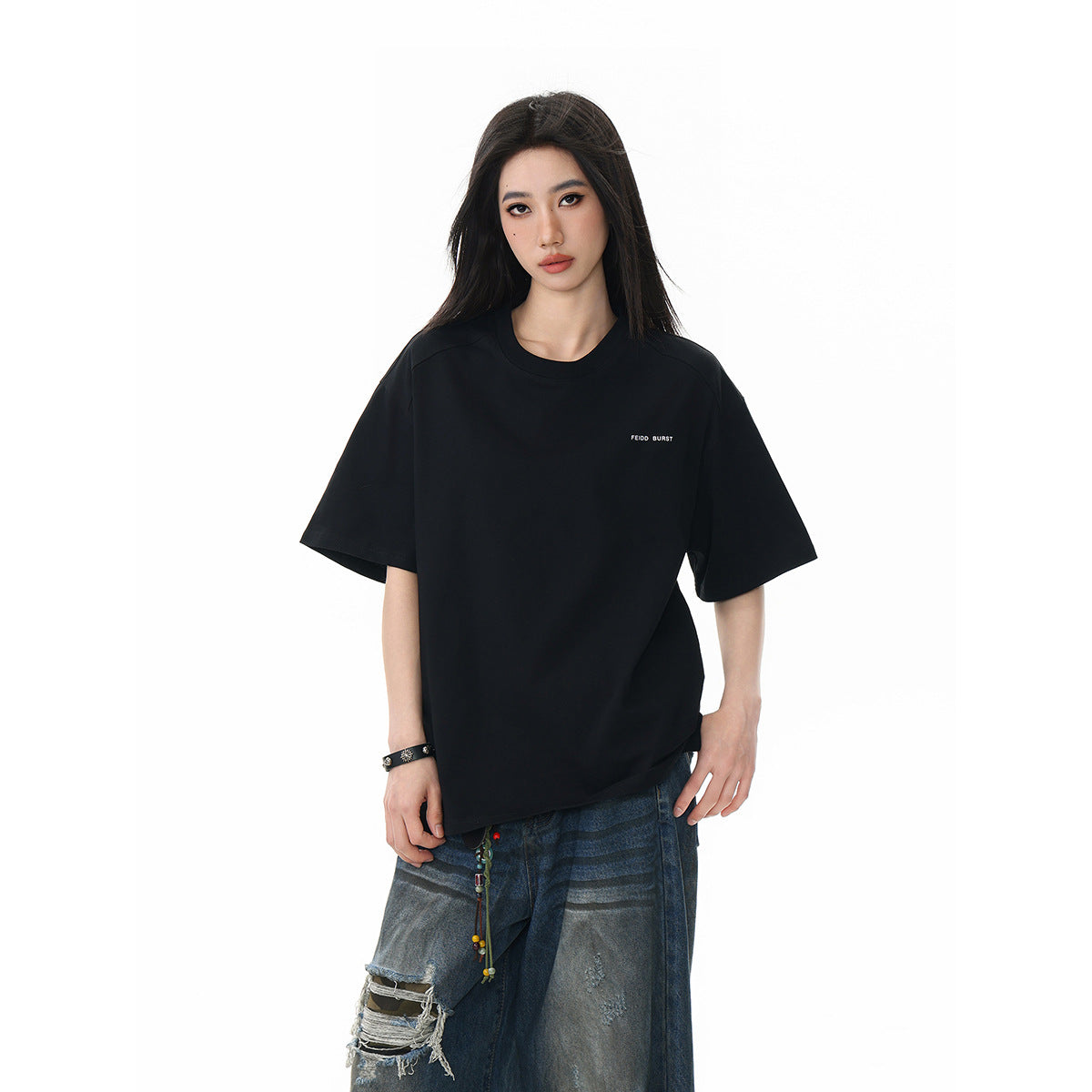 Model wearing an oversized black short-sleeve crew-neck T-shirt with small white chest text, shown from the front.