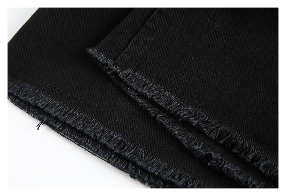 Close-up of black trouser hems with frayed edges.