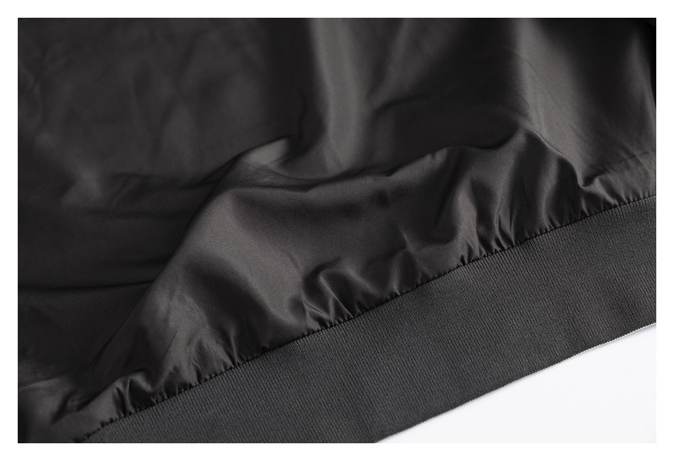 Close-up of a dark jacket's gathered lining and wide ribbed hem band.