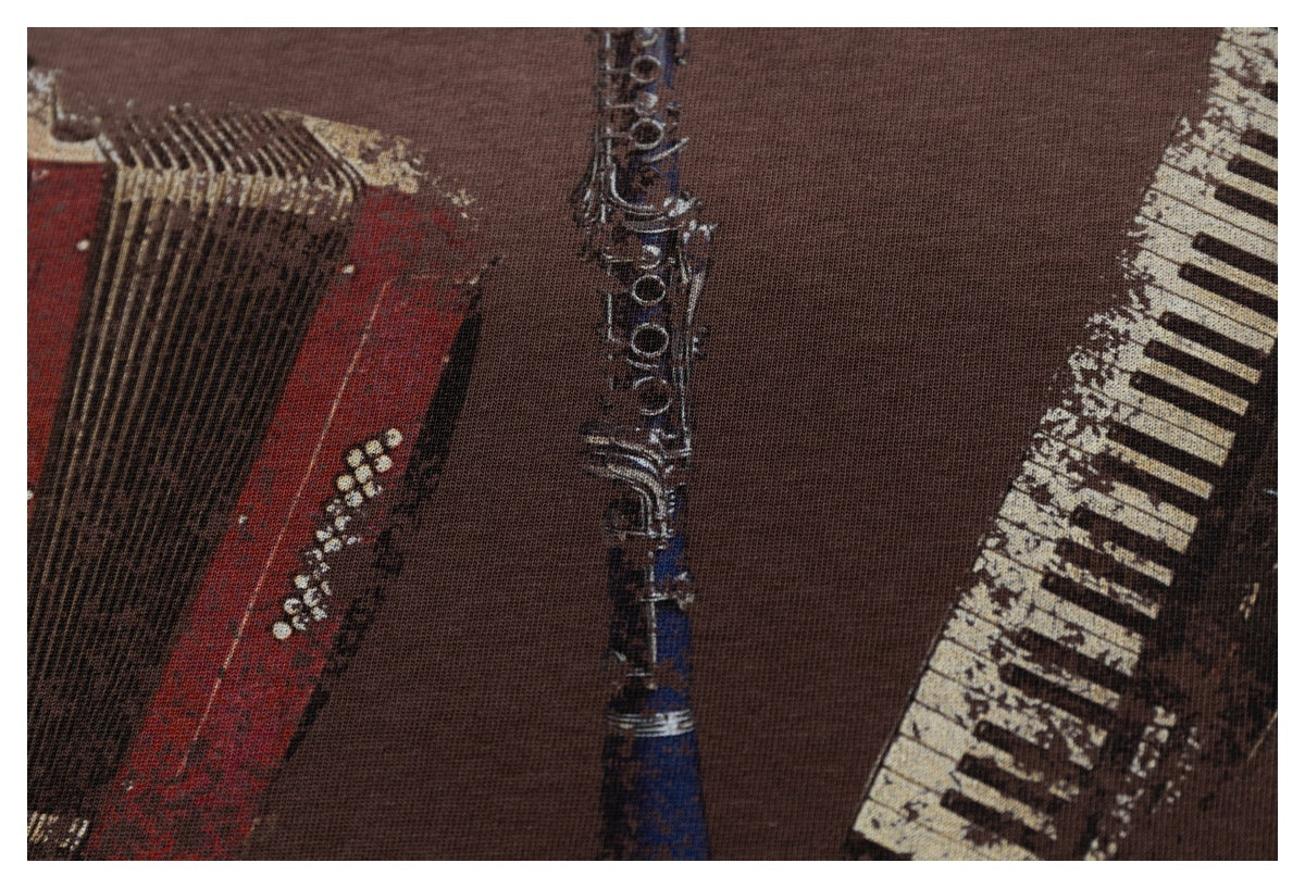 Close-up of the brown T-shirt print, with parts of an accordion, clarinet and keyboard.