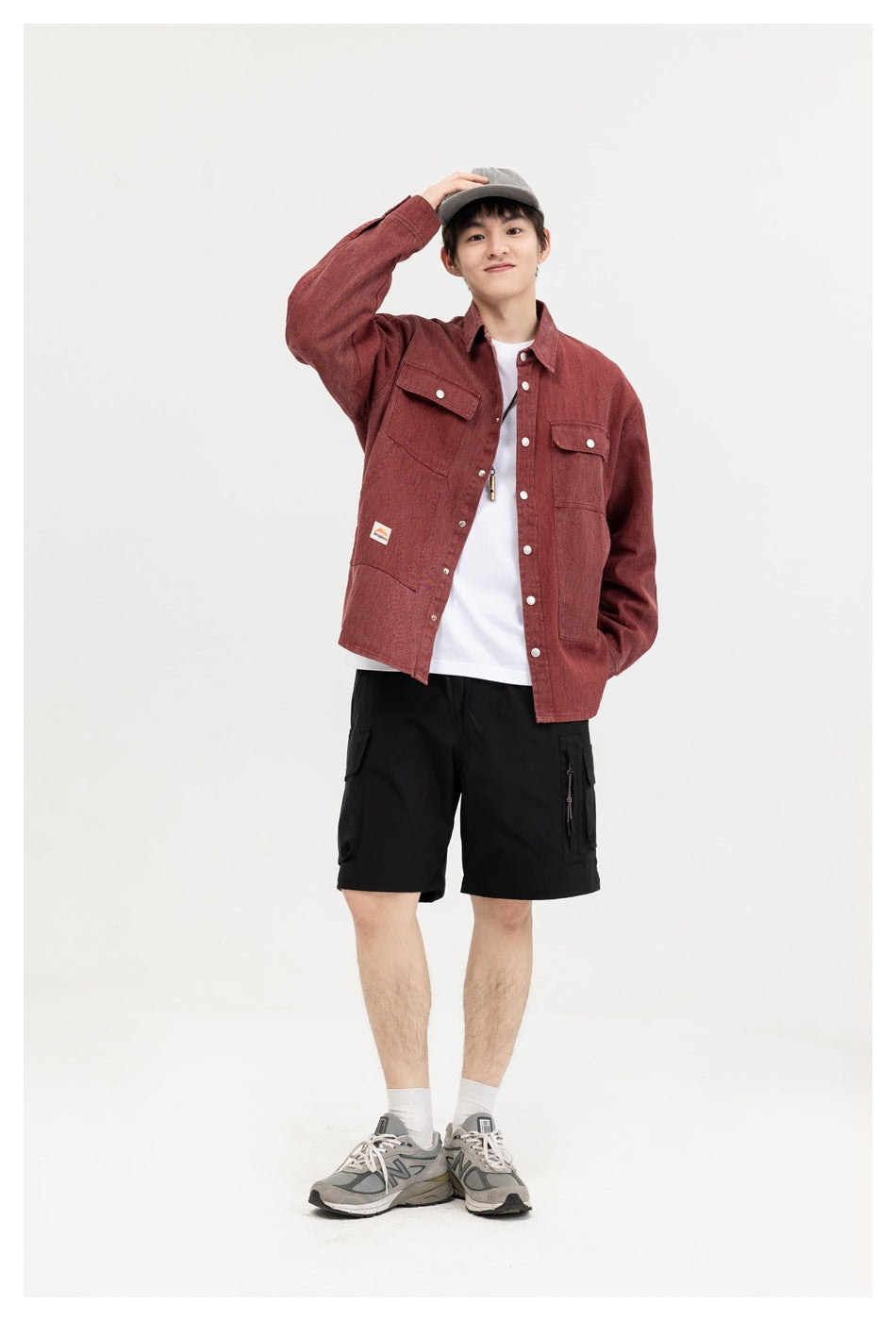 Model wearing a burgundy button-front shirt with flap chest pockets and large lower pockets, shown from the front.