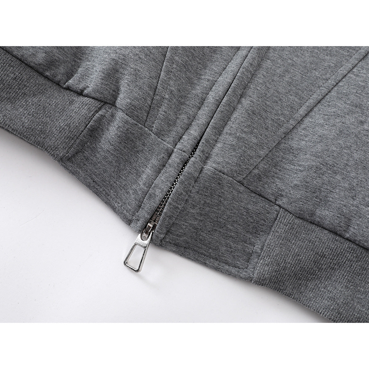 Close-up of the gray jacket's front zipper and ribbed hem.