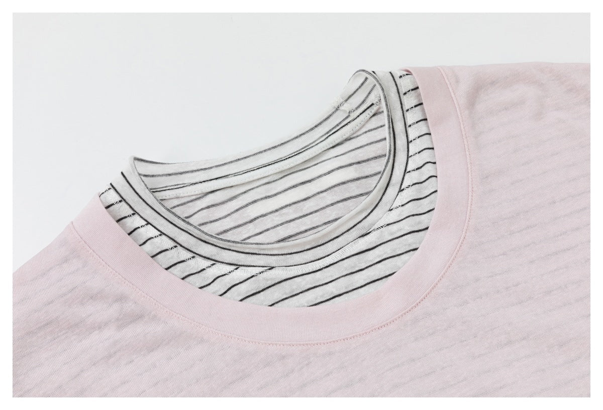 Close-up of the pale pink top's neckline layered over a white shirt with thin black stripes.