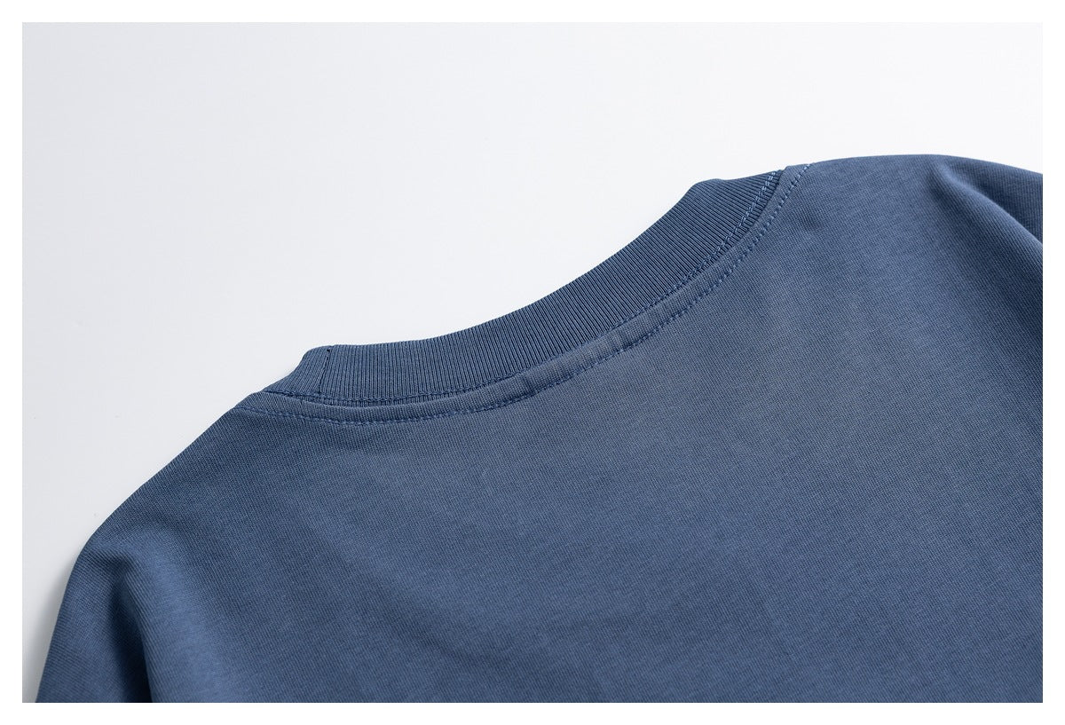 Close-up of the slate-blue T-shirt's plain back neckline and ribbed collar.