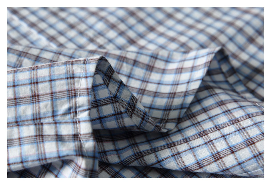 Close-up of the plaid shirt collar and stitching in white, blue, and brown checks.