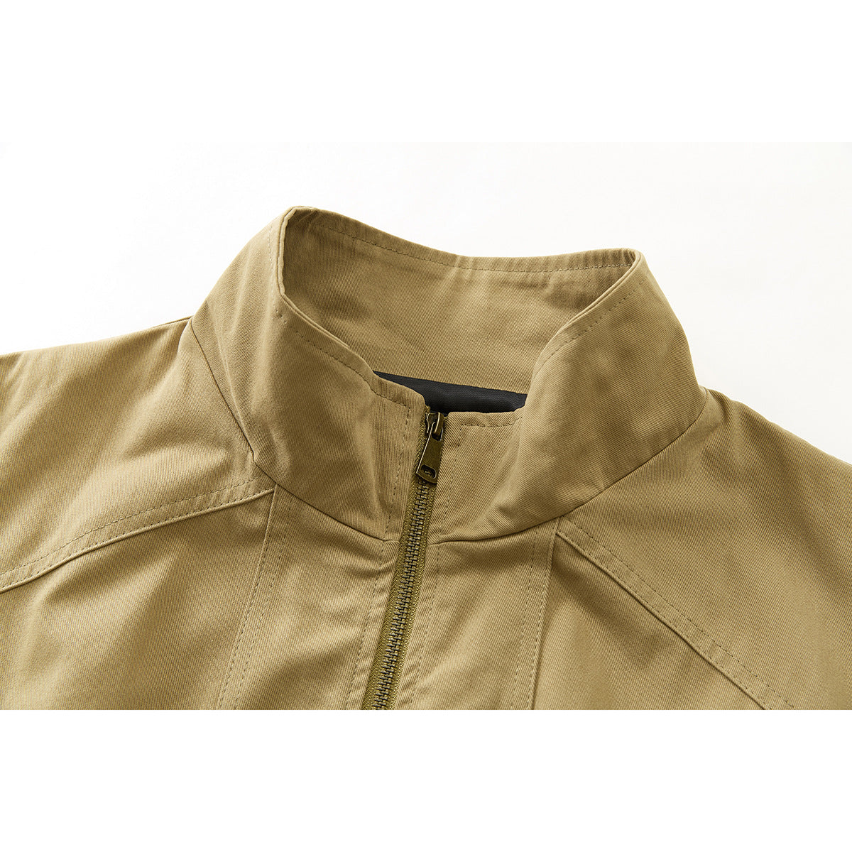 Close-up of a tan jacket's stand collar, front zipper and shoulder seams.