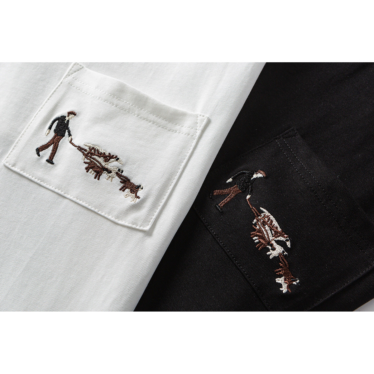 Close-up of white and black T-shirt chest pockets, each embroidered with a small figure and animals.