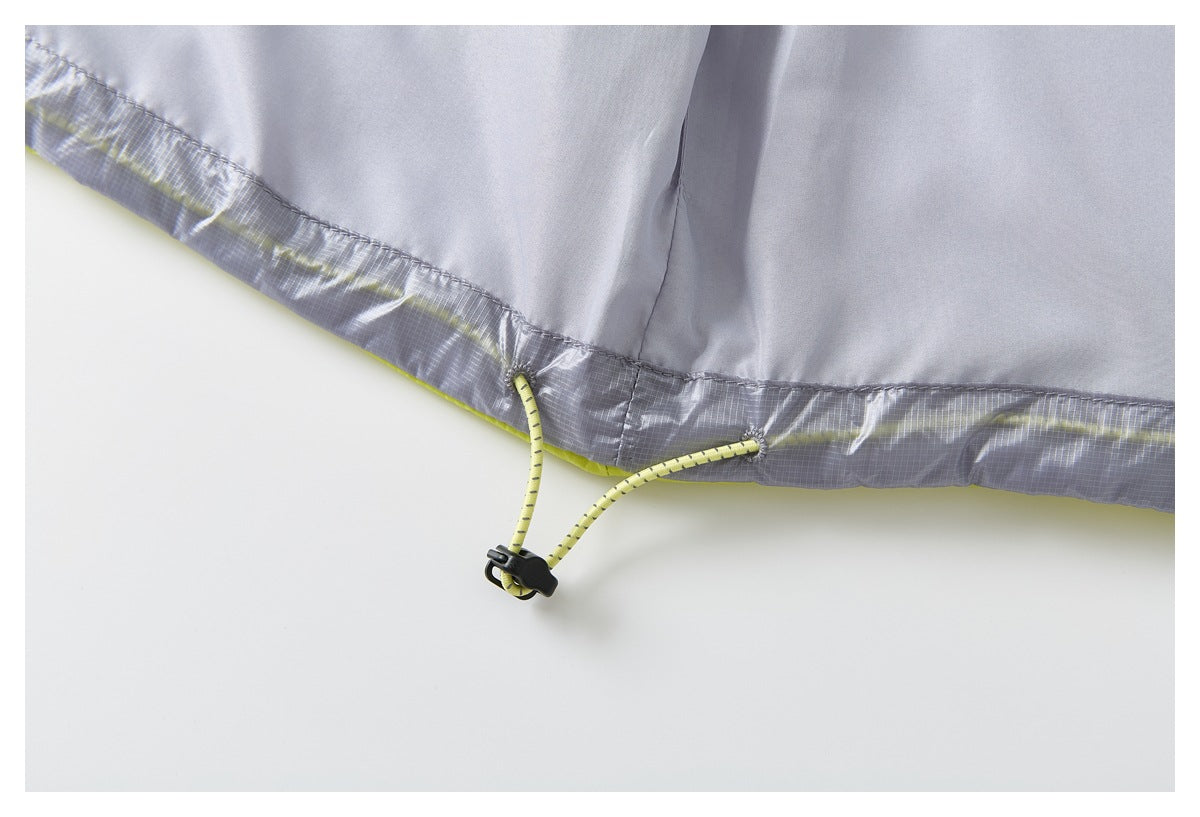 Close-up of a gray garment hem with a lime drawcord and black cord toggle.