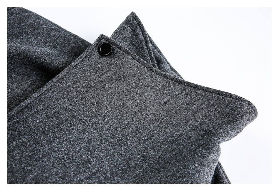 Close-up of a charcoal-gray flecked coat collar with a black button.