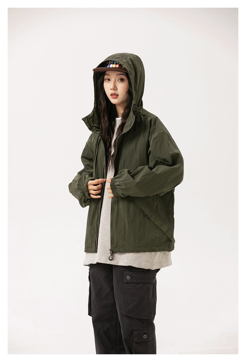 Model wearing an olive-green hooded jacket over a white shirt, with black cargo pants.