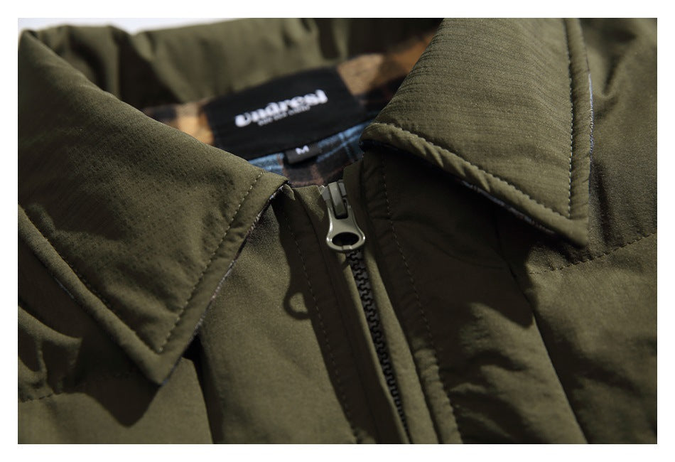 Close-up of an olive green jacket collar and front zipper, with a black neck label behind the collar.