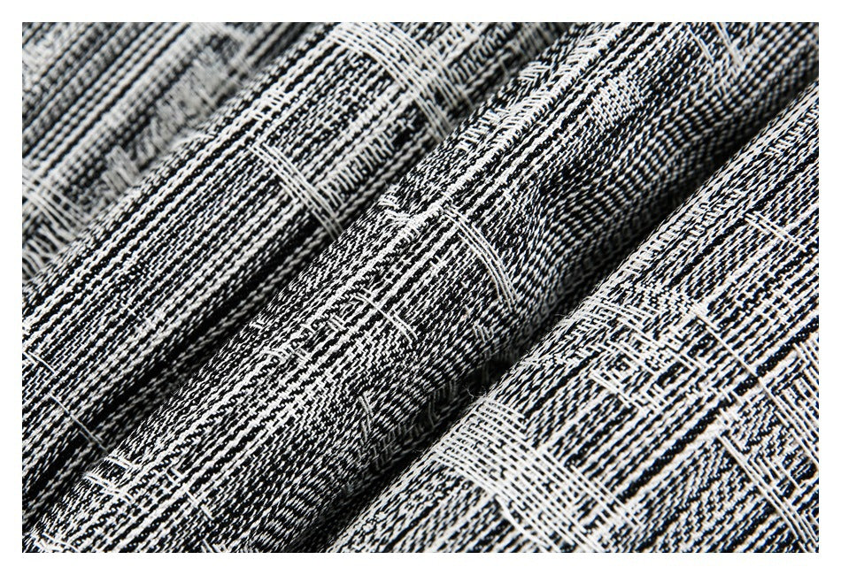 Macro view of the garment’s dense black-and-white woven pattern and folds.