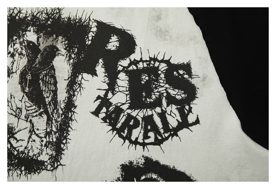 Close-up of distressed black graphic lettering and illustration printed on off-white T-shirt fabric.