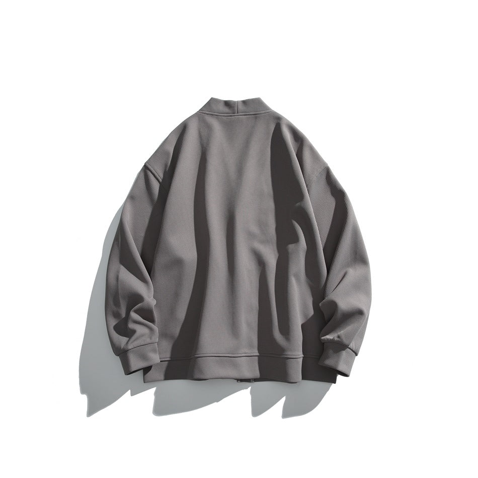 Back view of a gray loose-fit jacket with a short stand collar, long sleeves, ribbed cuffs and hem.