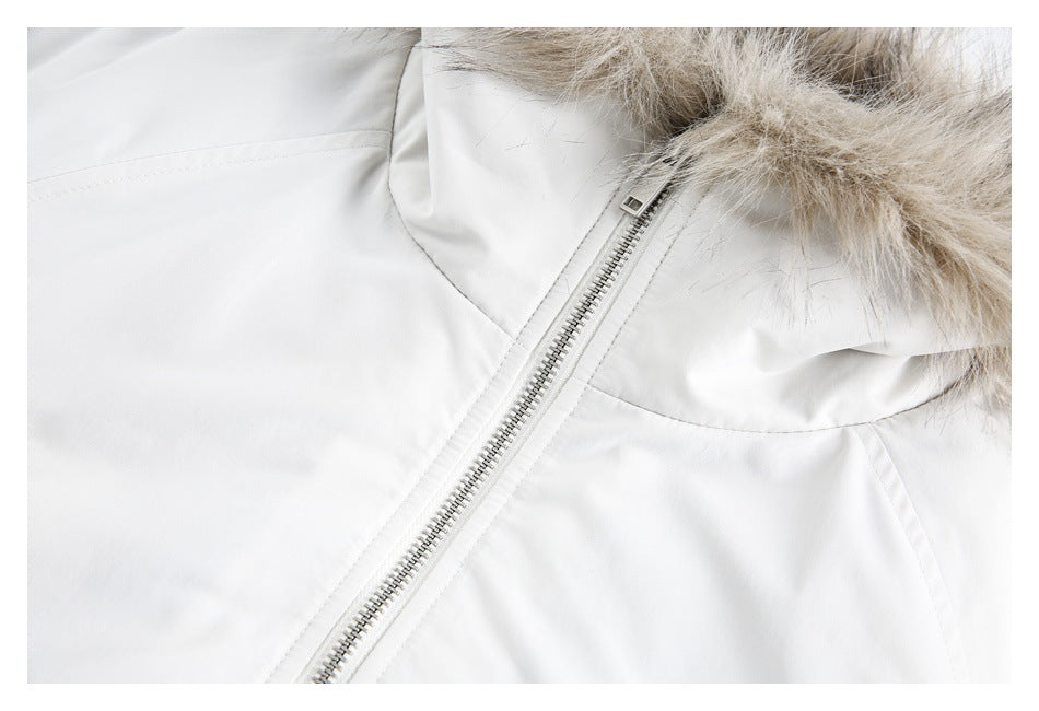 Close-up of a white jacket's diagonal front zipper and beige-gray fur hood trim.