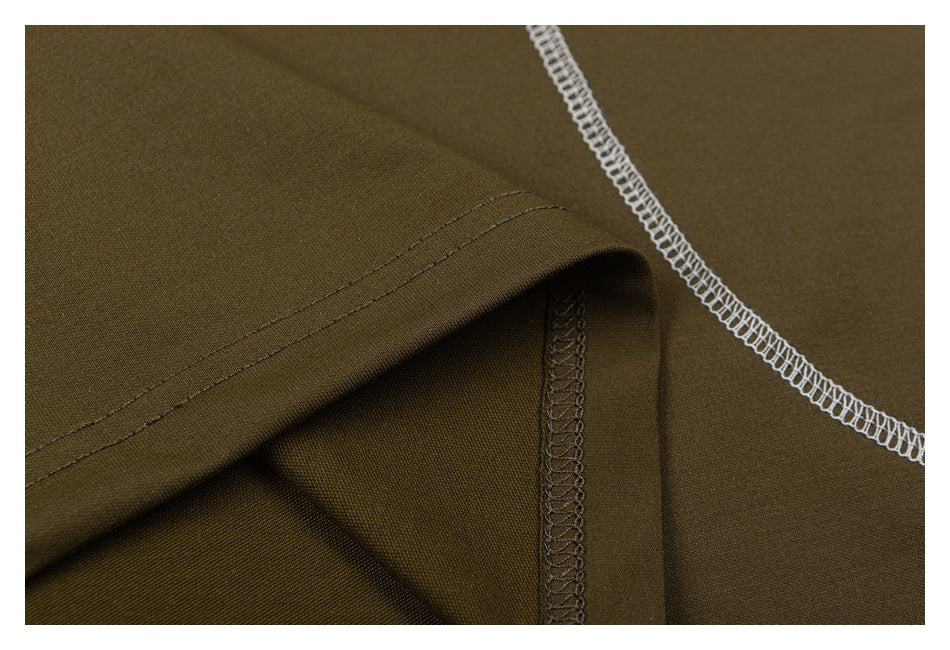 Close-up of olive-brown fabric with folded seams and contrasting white overlock stitching.