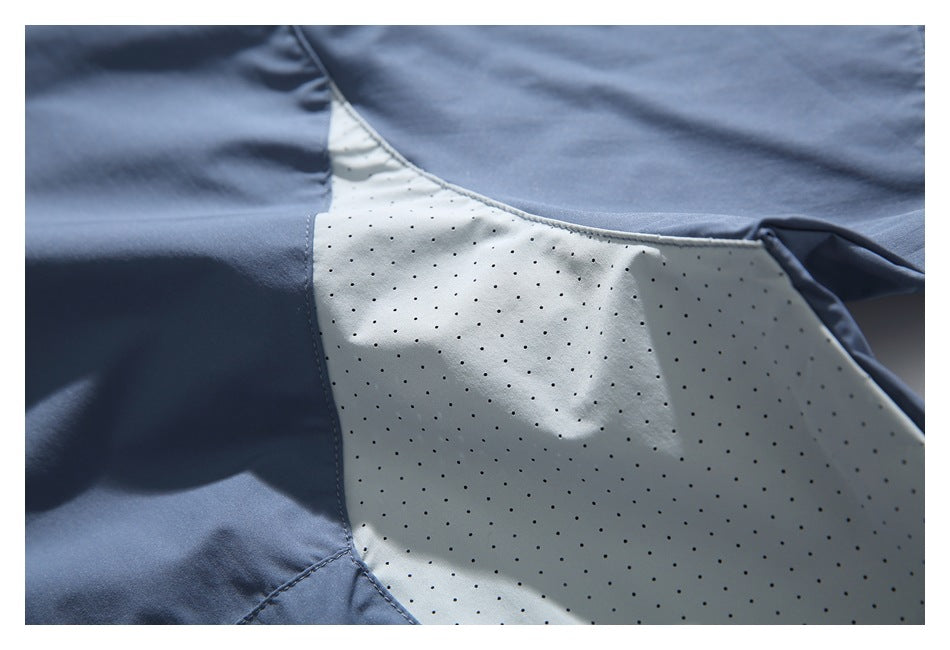 Close-up of a pale perforated panel joined to slate-blue fabric on the jacket.