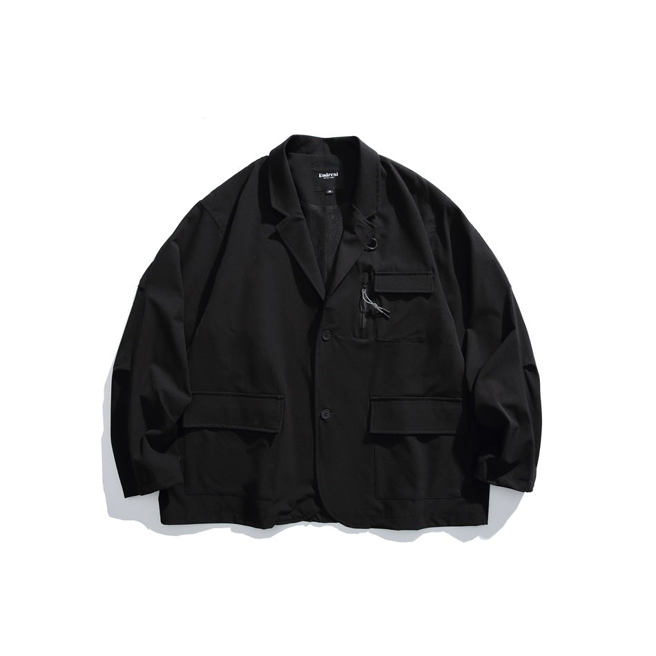 Black blazer-style jacket flat lay with notch lapel, two buttons, zip chest pocket and large flap pockets