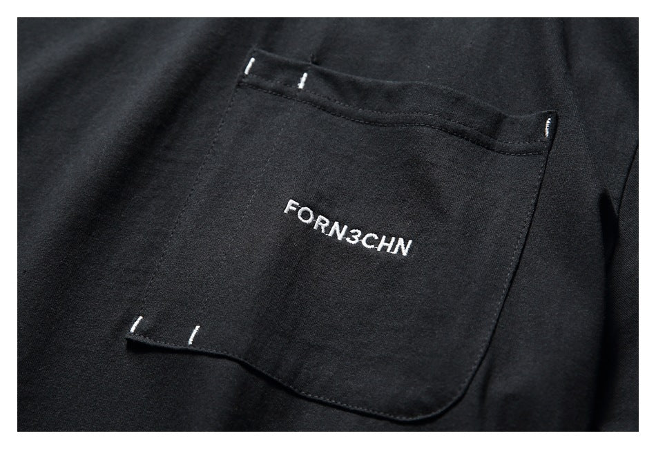 Close-up of a black T-shirt pocket with white embroidered lettering and small contrast stitches.