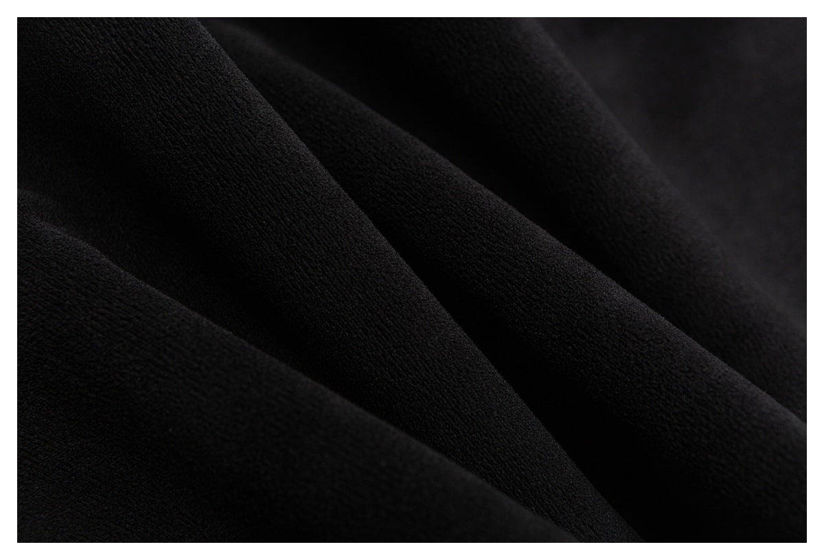 Macro view of black fabric with a fine textured surface and soft folds.