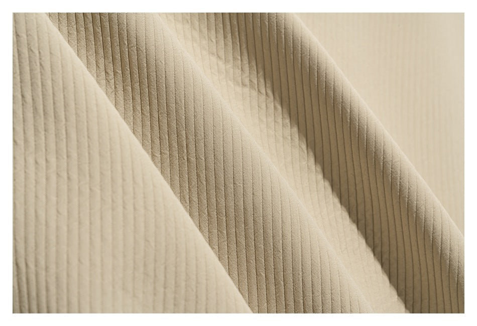 Close-up of beige fabric folds showing narrow vertical ribs and a soft drape.