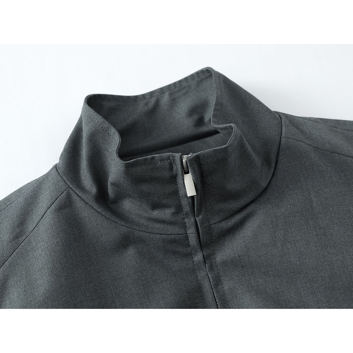 Close-up of a charcoal gray jacket's stand collar and silver center zipper.