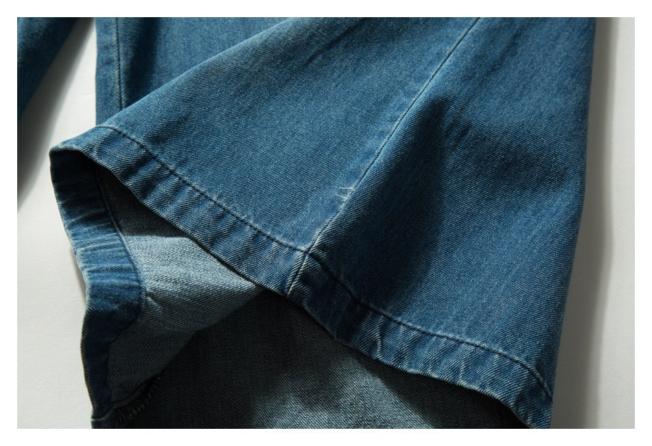 Close-up of a folded blue denim leg opening and its stitched hem.