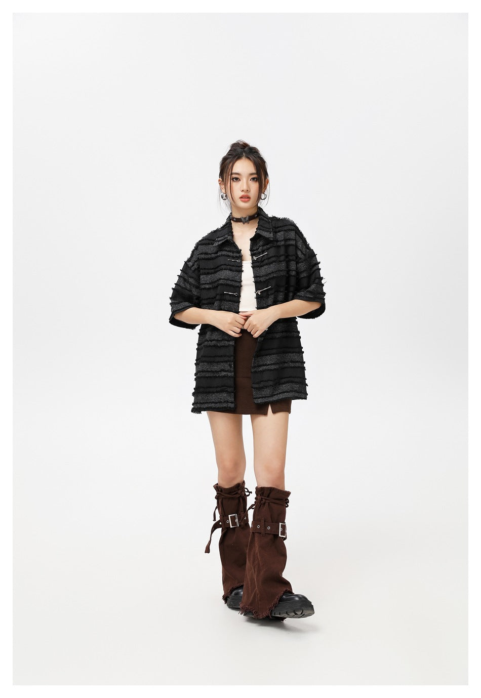 Model wearing the black and gray striped short-sleeve shirt open over a white top with a brown skirt and brown leg warmers