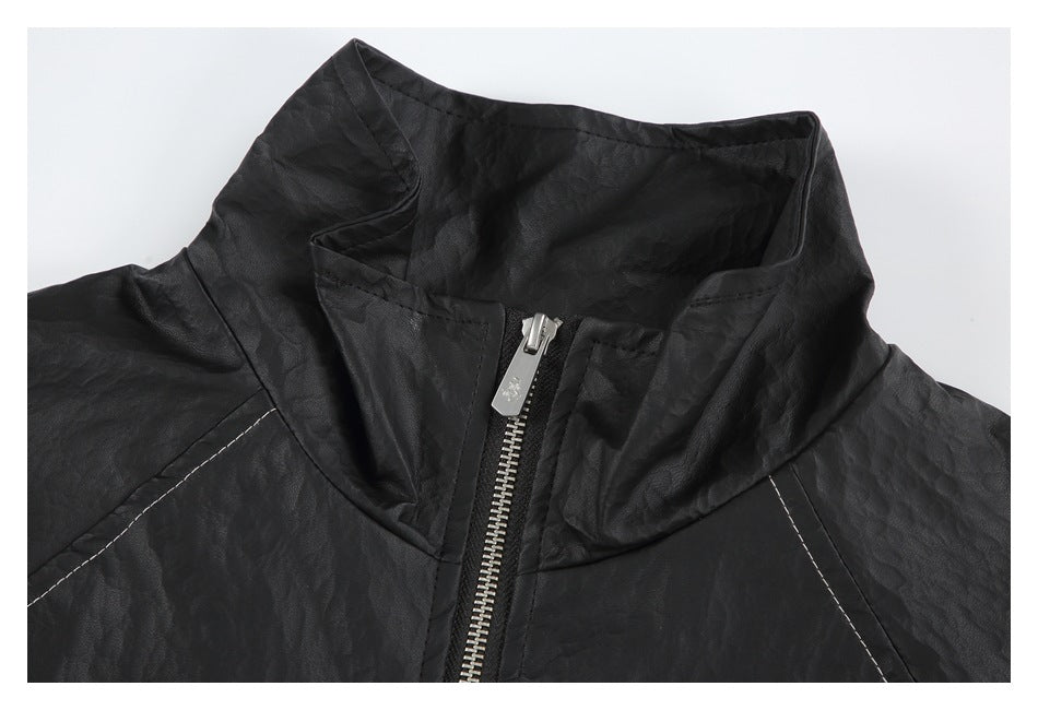 Close-up of the black jacket’s stand collar and silver zipper pull with contrast stitching at the shoulders.