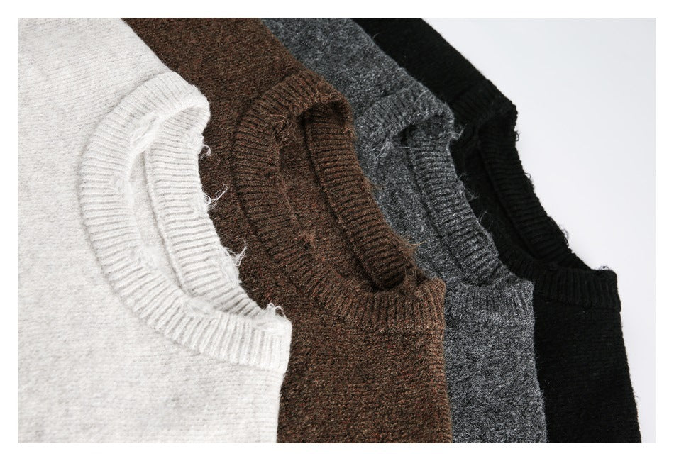 Close-up of four crewneck sweaters in light gray, brown, charcoal gray, and black.