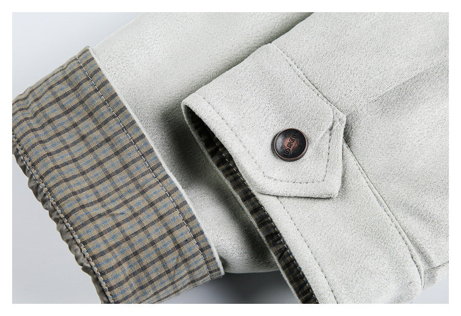 Close-up of a light gray jacket cuff with beige-and-blue plaid lining and a dark button.
