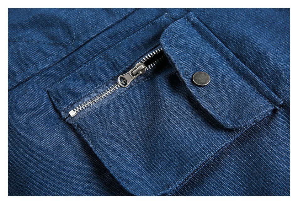 Close-up of a blue jacket pocket with a metal zipper and snap-button flap.