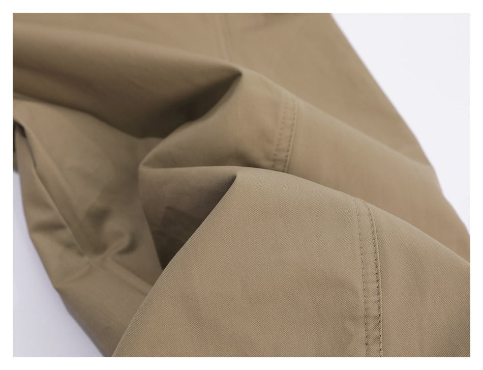 Close-up of taupe trouser fabric and a stitched seam.