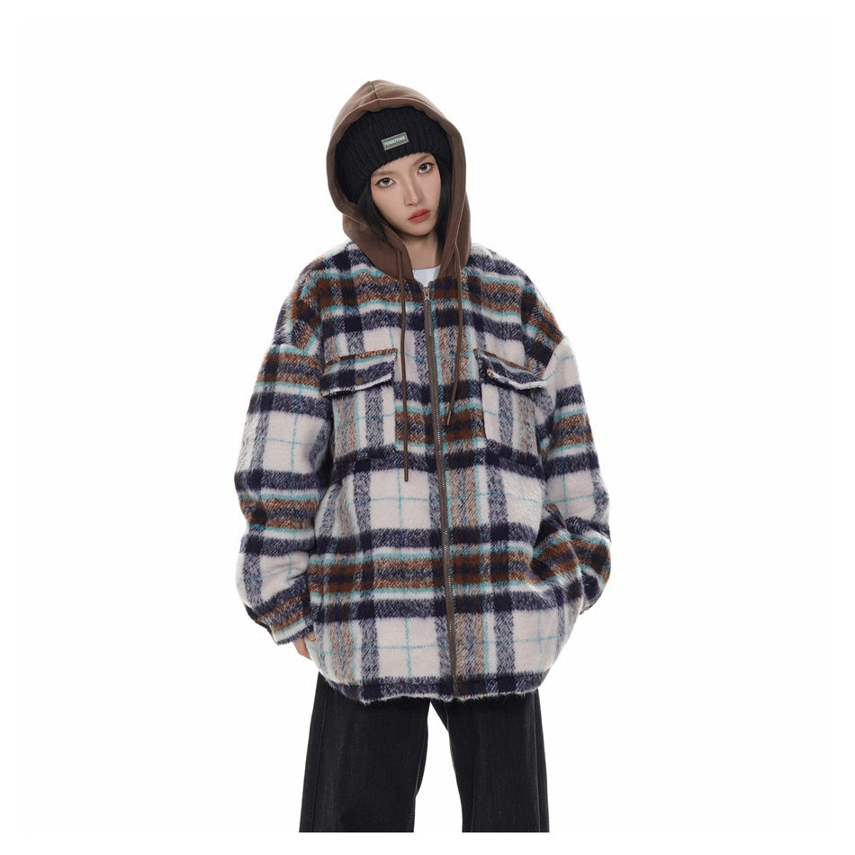 Model wearing a white, navy, teal, and brown plaid hooded zip jacket with black wide-leg trousers.
