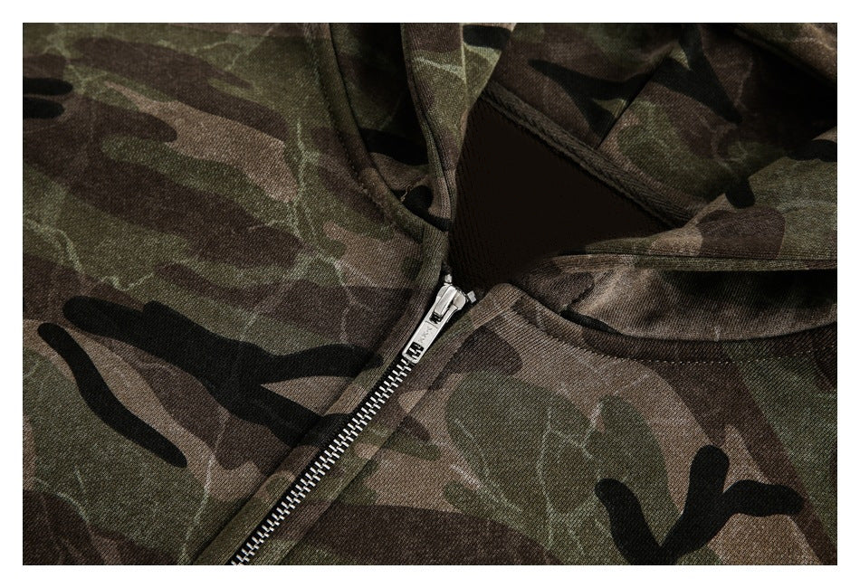 Close-up of a camouflage hoodie neckline and silver front zipper.