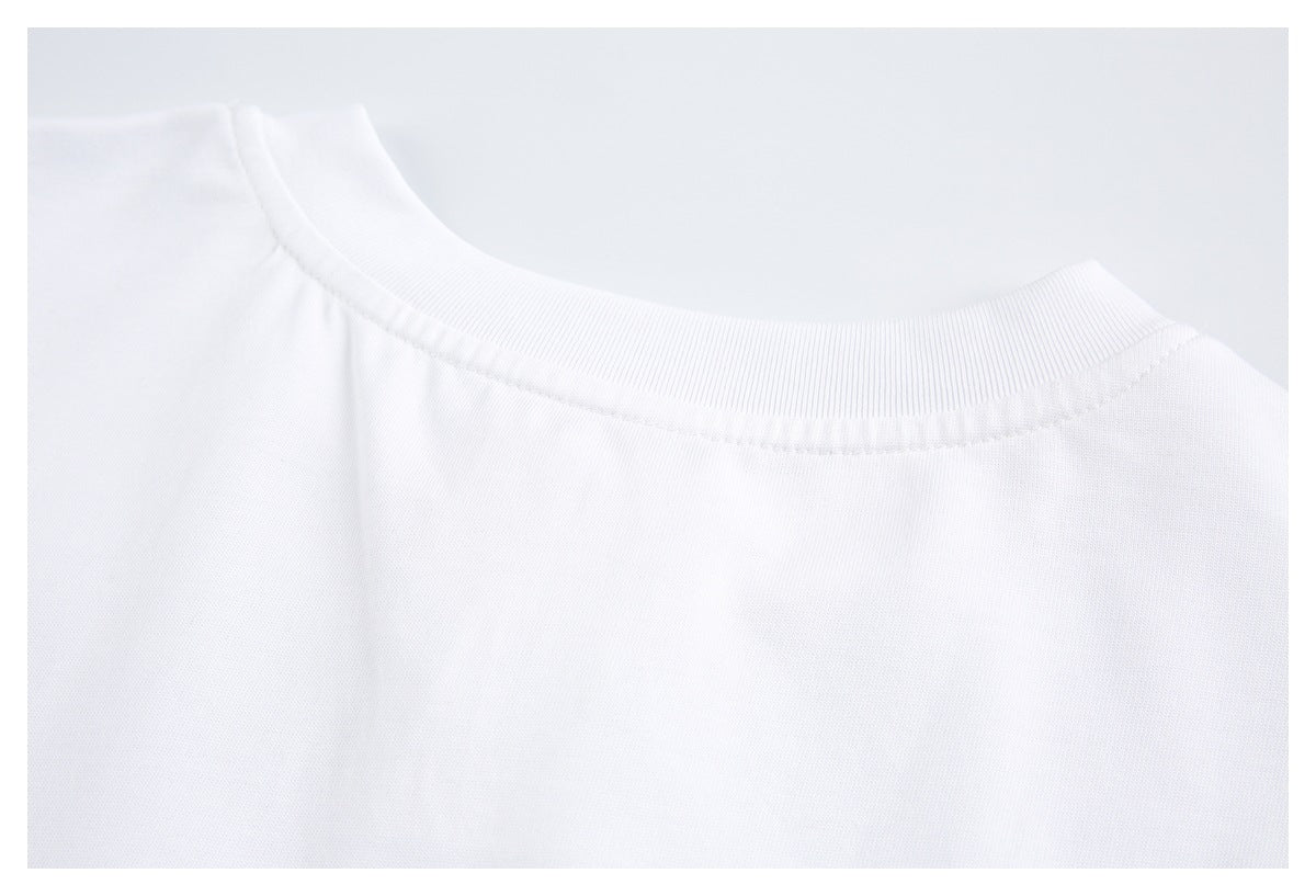 Close-up of a white shirt's ribbed crew neckline and shoulder seam.