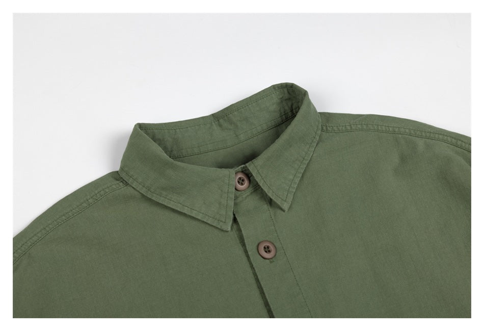 Close-up of the olive-green jacket's pointed collar, shoulder seams and brown buttons.