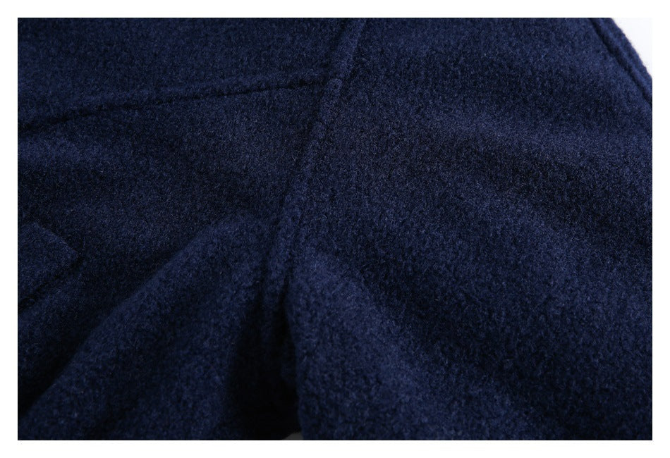 Extreme close-up of the navy jacket's textured fabric and seam.