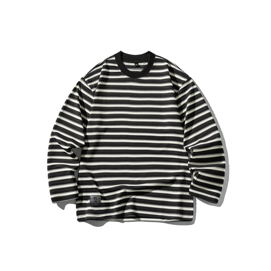 Black long-sleeve crew-neck top with cream horizontal stripes, black collar and small patch at lower hem