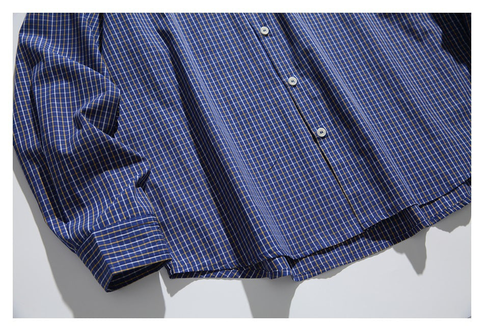 Close-up of the blue checked shirt's buttons, sleeve cuff, and curved hem.