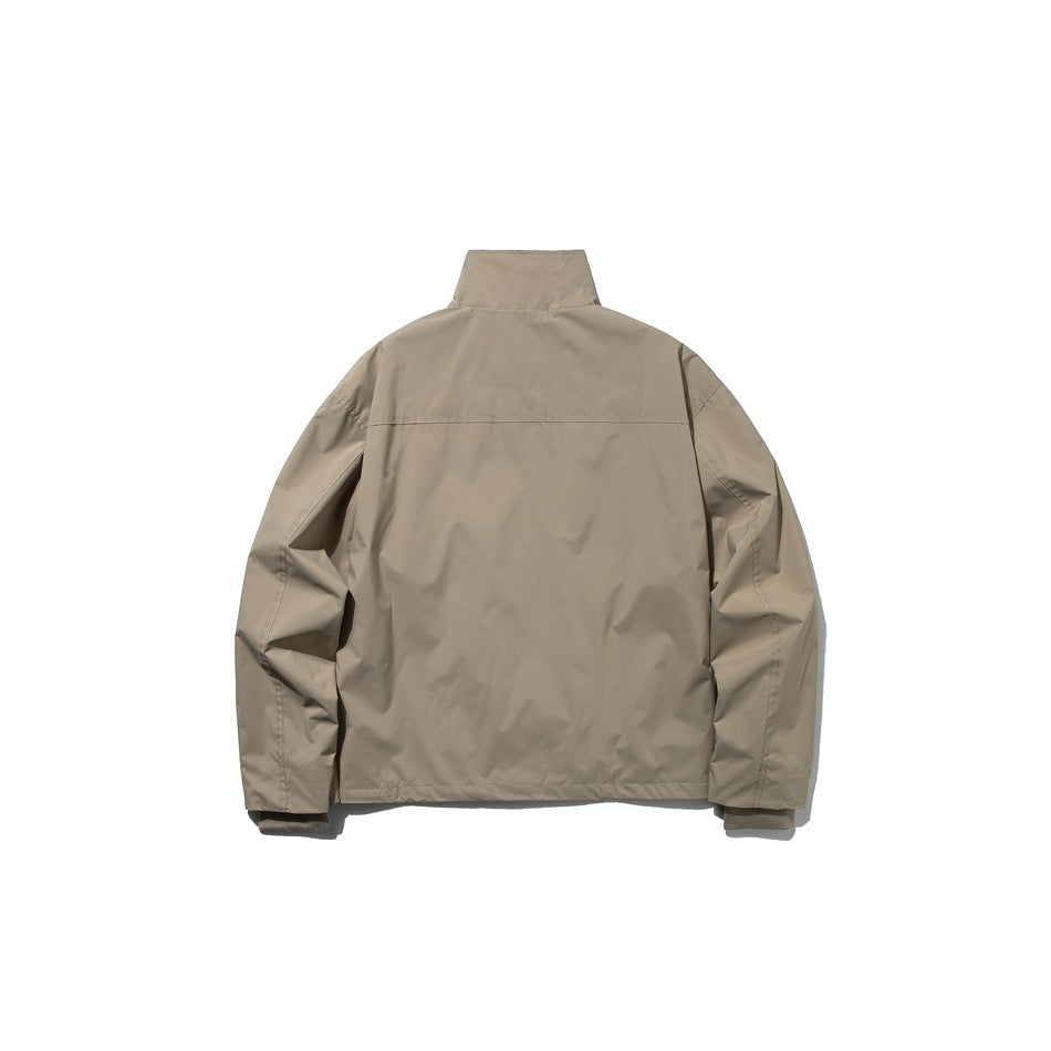 Back view of a taupe jacket with a stand collar, long sleeves, and a horizontal upper-back seam.
