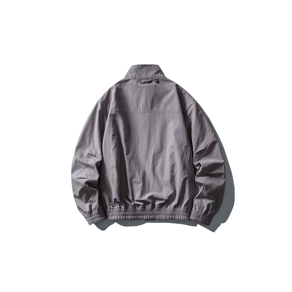 Back view of a solid muted gray-purple jacket with a stand collar, gathered cuffs, and elasticated hem.