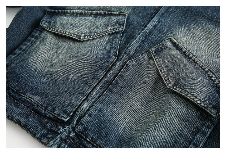 Close-up of two faded blue denim jacket pockets with pointed flaps and tan stitching.