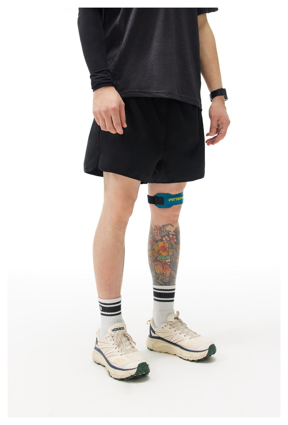 Front three-quarter view of a model wearing black athletic shorts and a dark shirt.