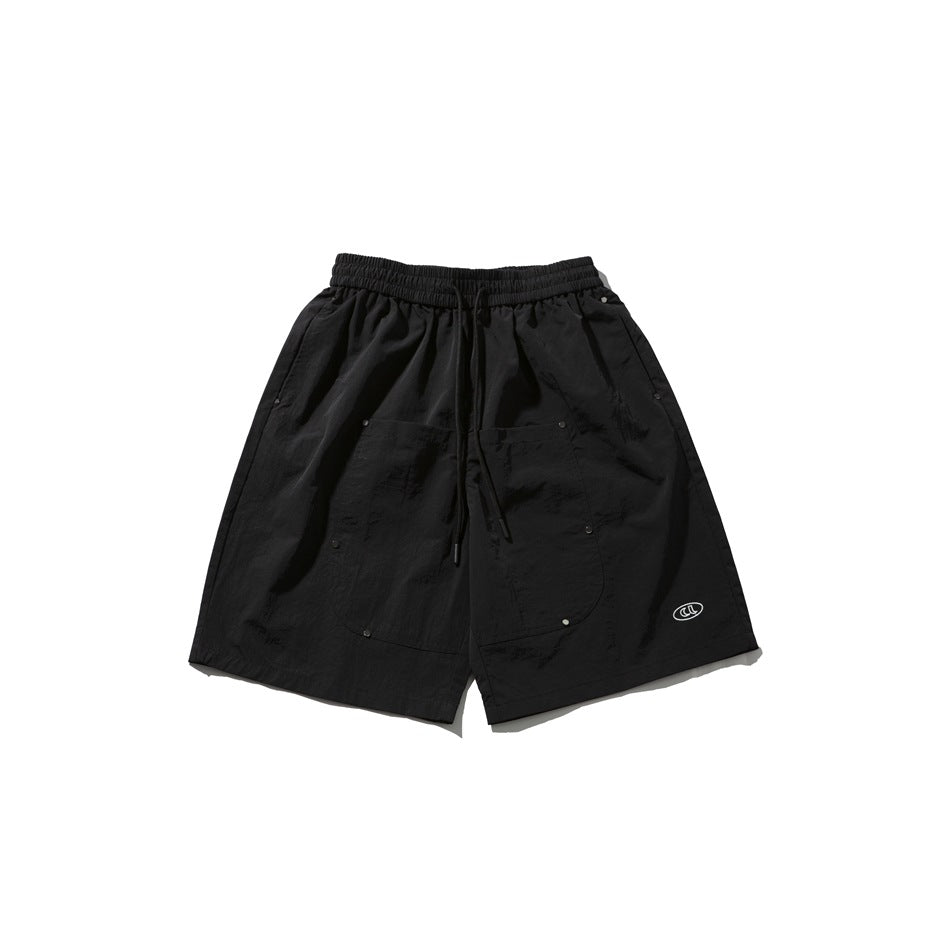 Black knee-length shorts with elastic drawstring waist, front patch pockets with studs and small oval logo
