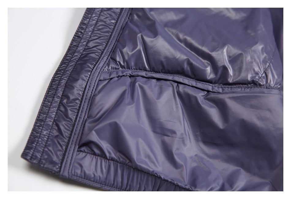 Close-up of a dark slate-purple jacket interior with smooth lining, stitched panels, and a bound edge.