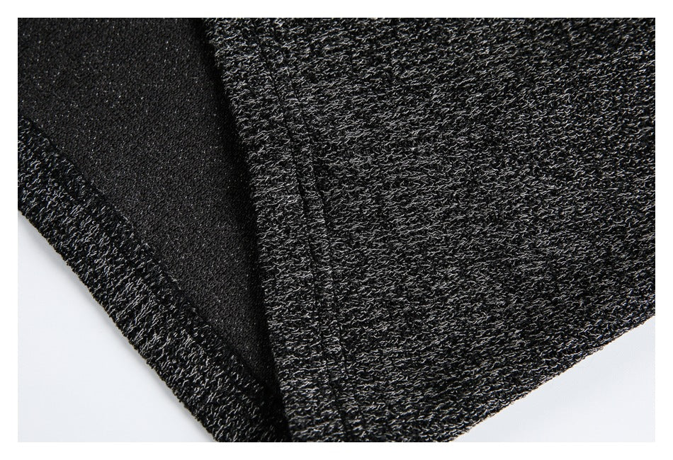 Close-up of a folded seam showing the textured dark charcoal knit and its underside.