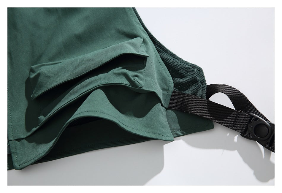 Close-up of a dark green garment hem, mesh panel, and black adjustable strap with buckle.